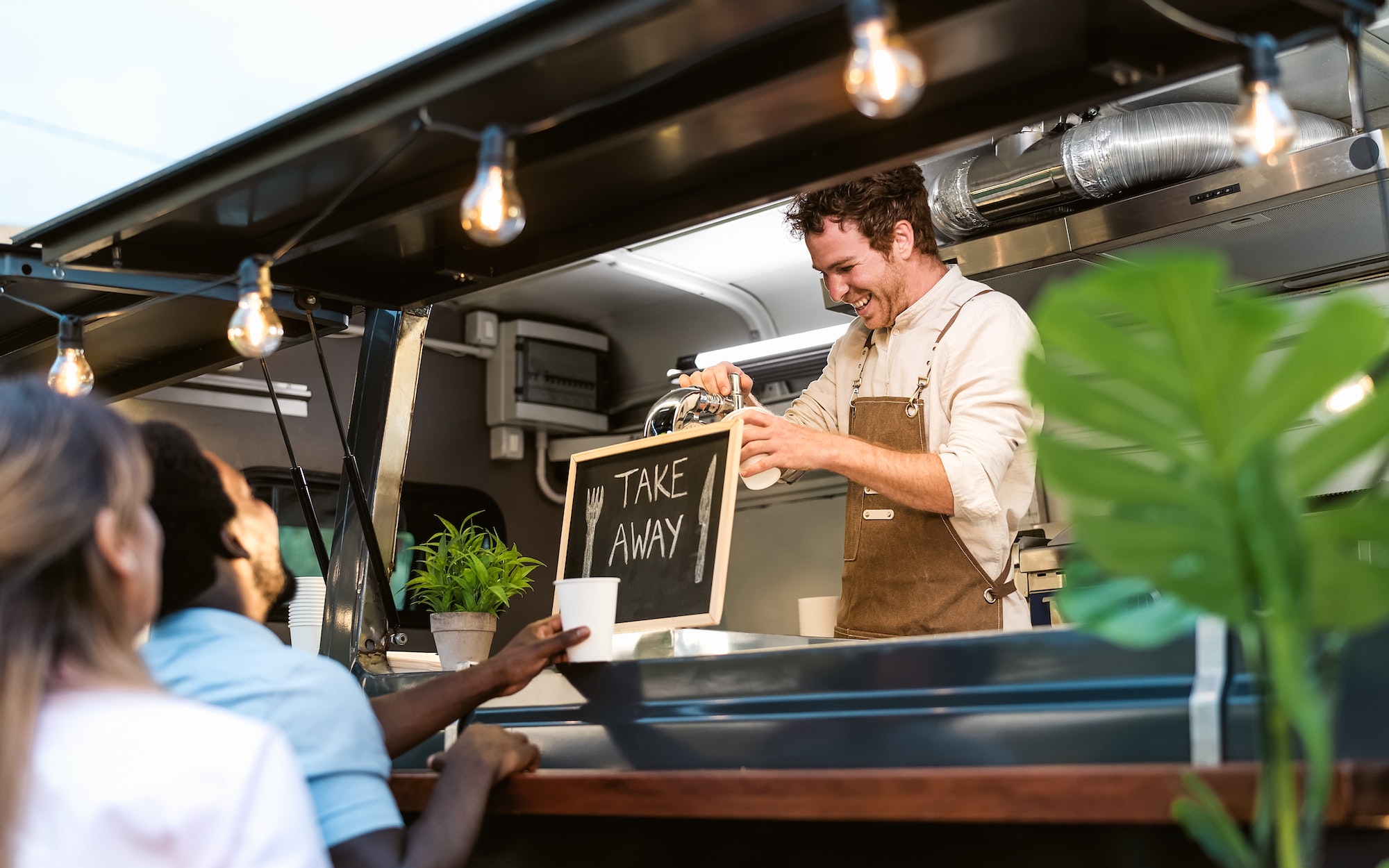 Happy multiracial people buying meal from street food truck market