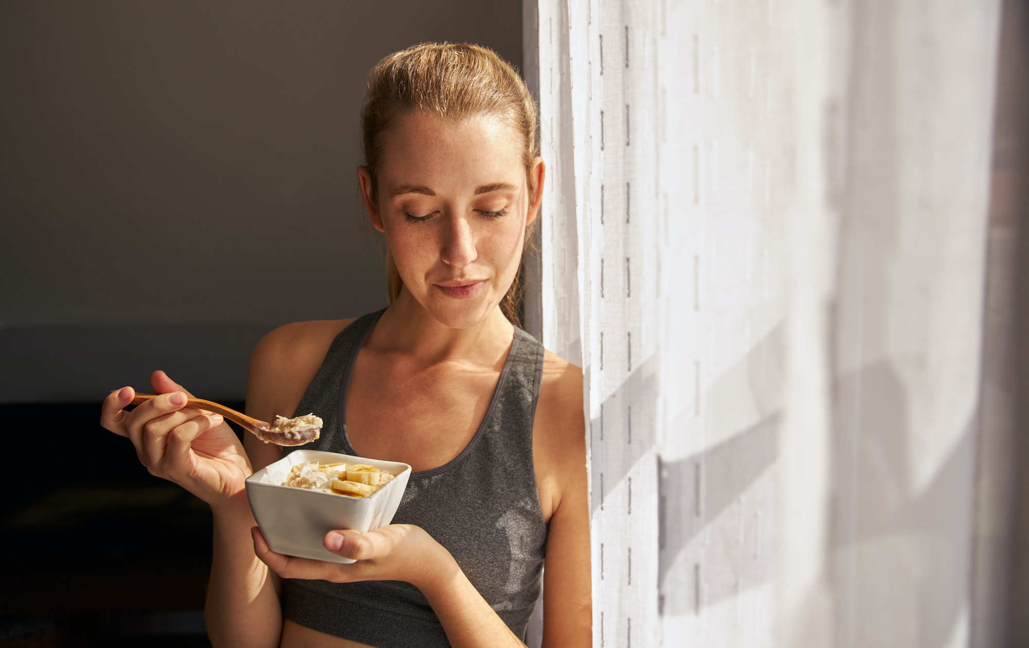 Young female holding healthy breakfast bowl